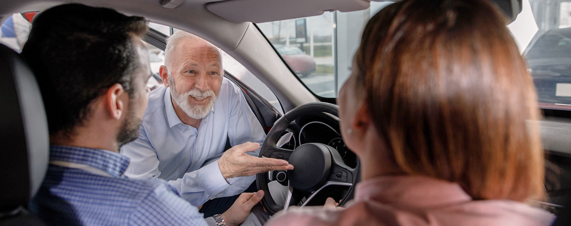 Photo of a couple speaking to a car sales person